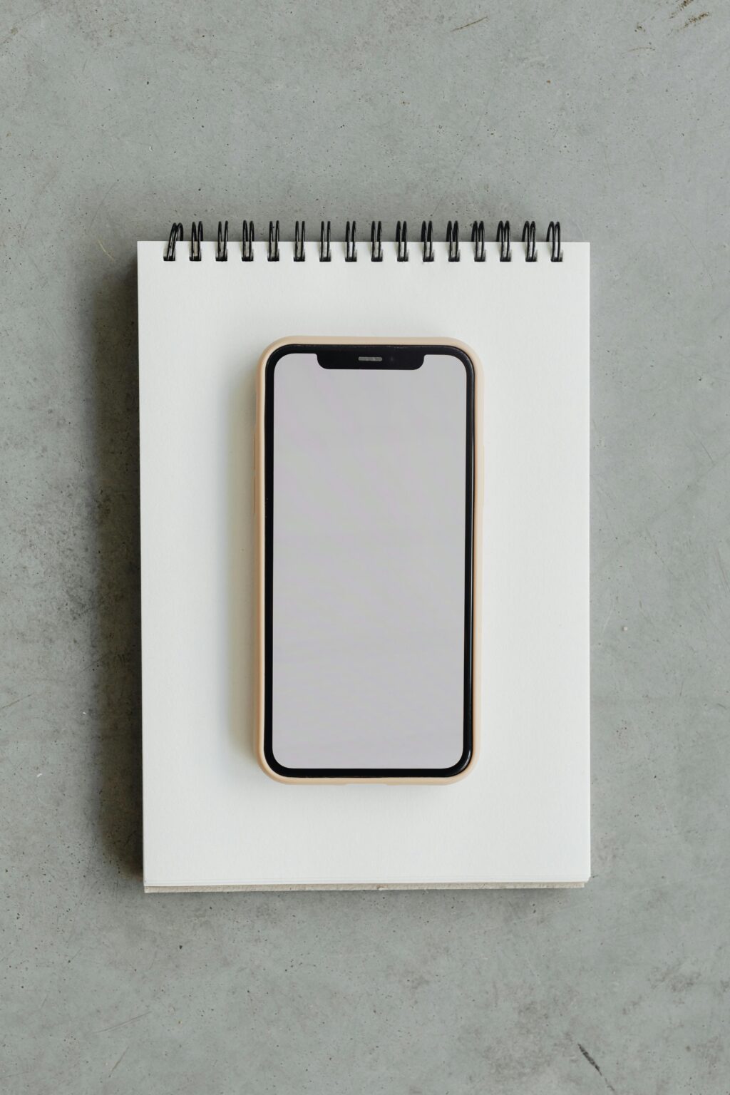 Minimalist smartphone mockup on a notepad, perfect for design projects.